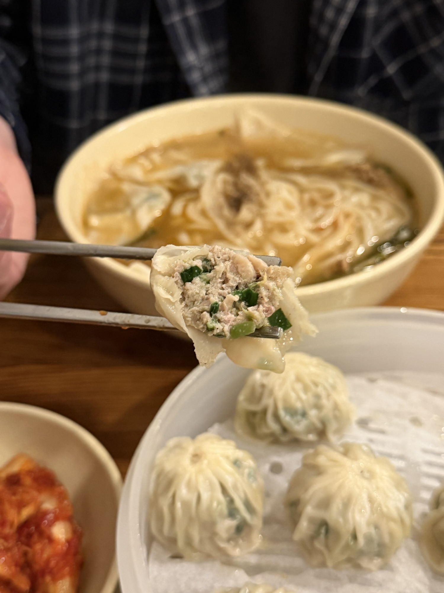 Bitten-open Myeongdong Kyoja mandu showing ground pork and chive filling