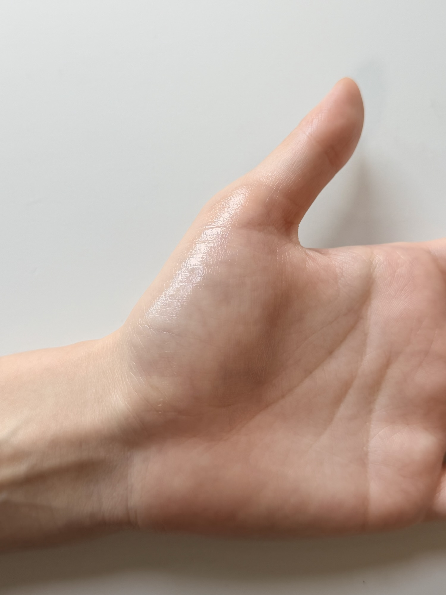 Back of a hand after Medicube PDRN Pink Peptide Serum has fully absorbed — dewy glow finish with subtle luminosity and no residue