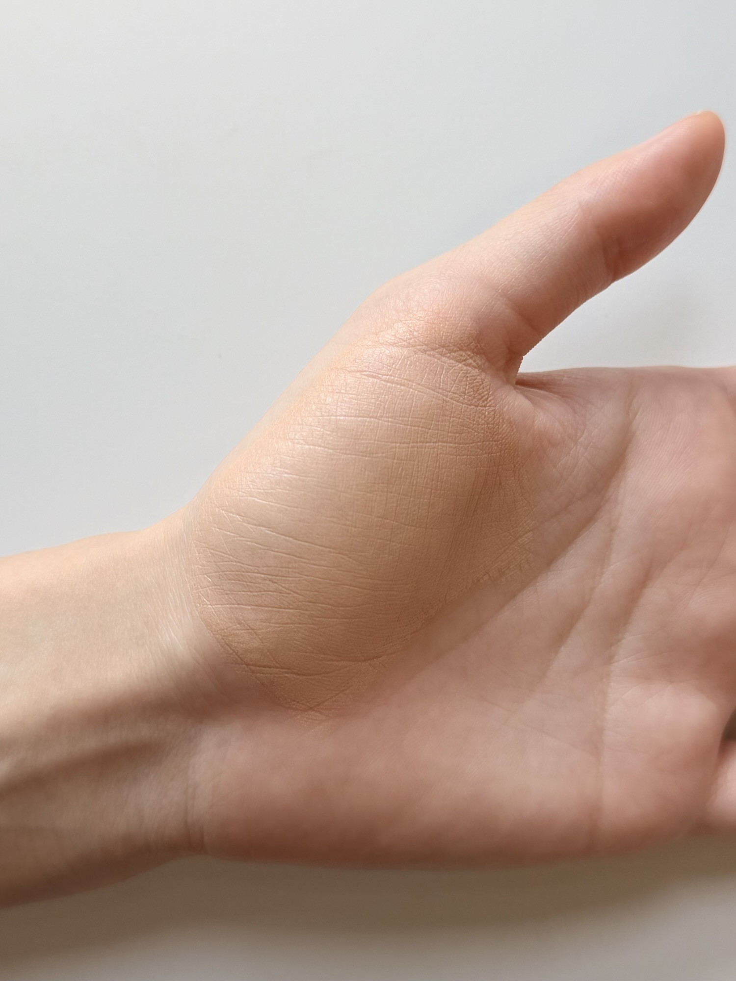 Back of a hand showing the natural subtle glow finish after Medicube PDRN serum was mixed into foundation and fully absorbed