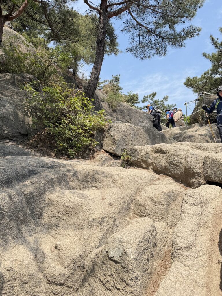 Narrow rocky path near Inwangsan summit — single-file only, hikers must yield to those descending