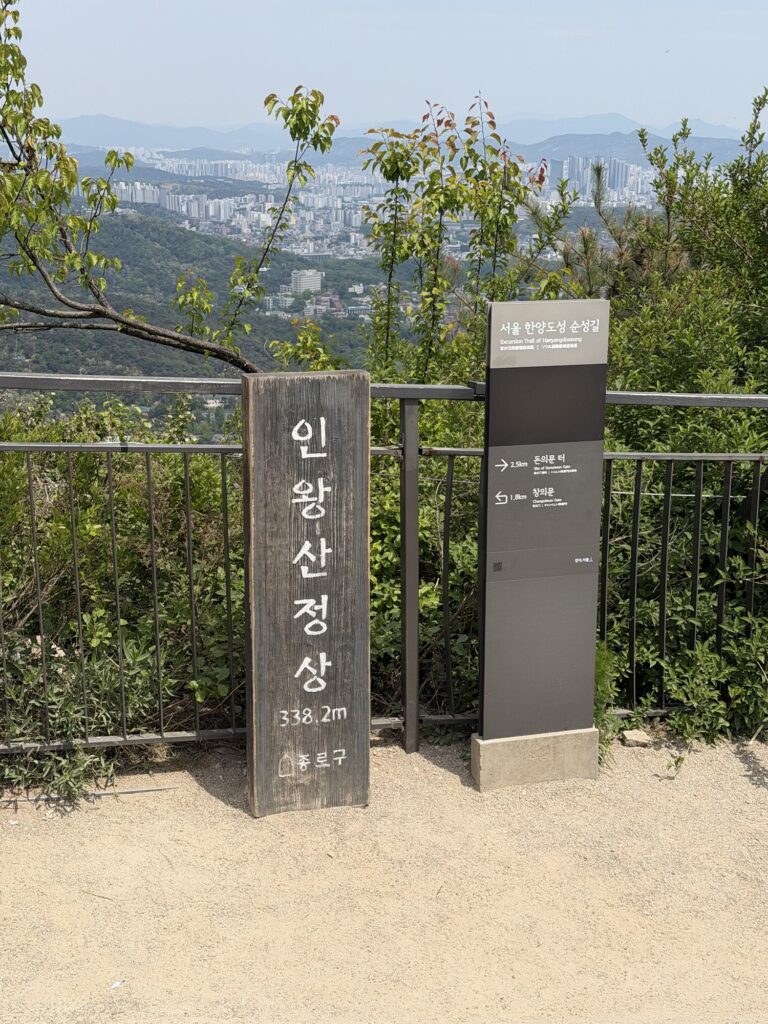Inwangsan summit marker stone at 338m elevation, hikers at the top