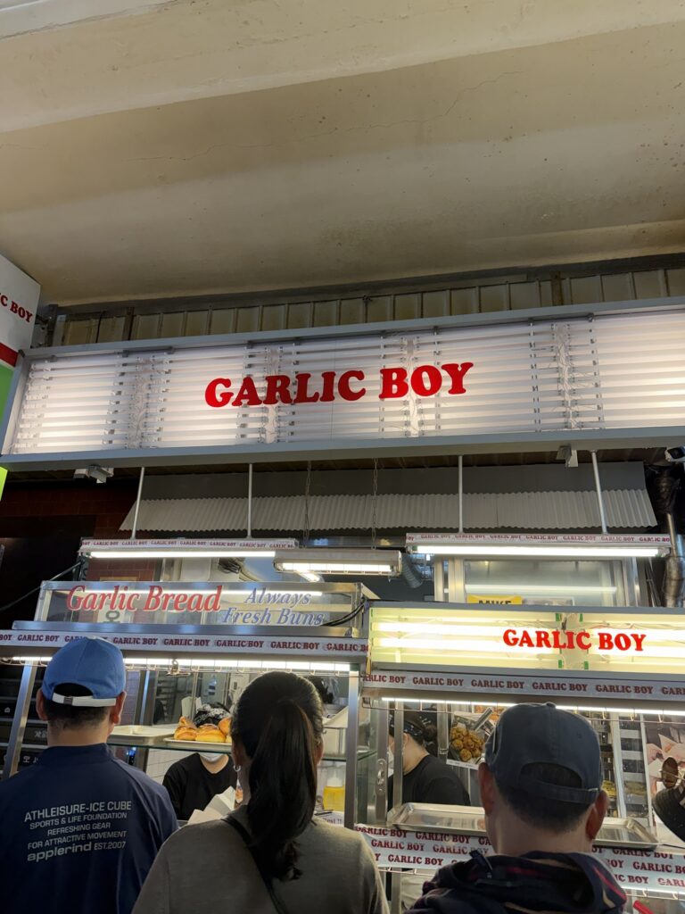 Garlic Boy storefront at Gwangjang Market with red GARLIC BOY signage and a small queue of customers