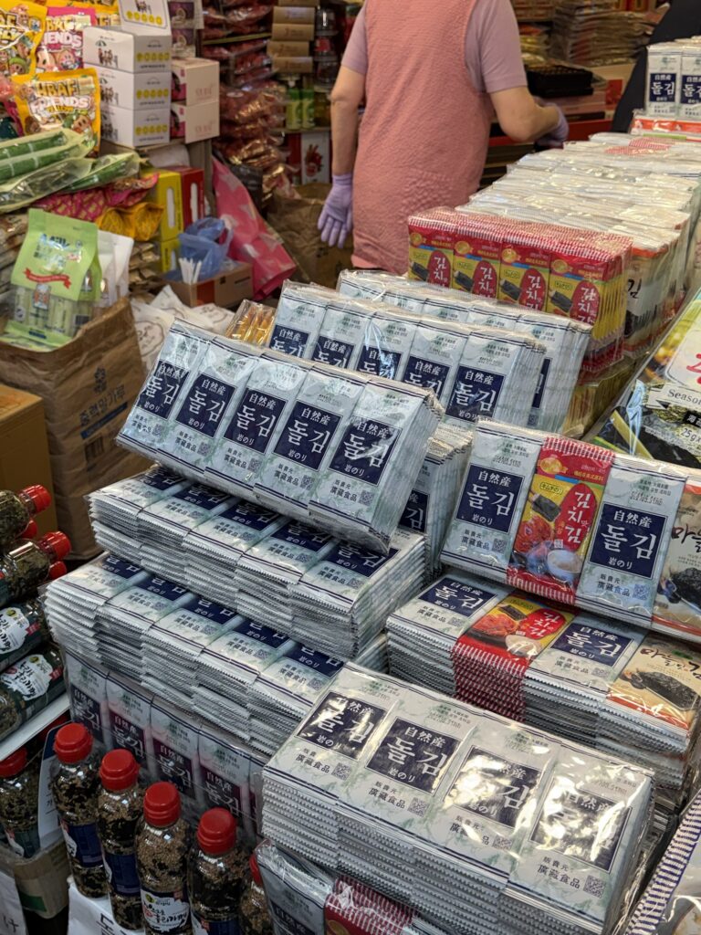 Stacks of packaged Korean seasoned gim (seaweed/nori) at a Gwangjang Market souvenir stall, popular with foreign tourists