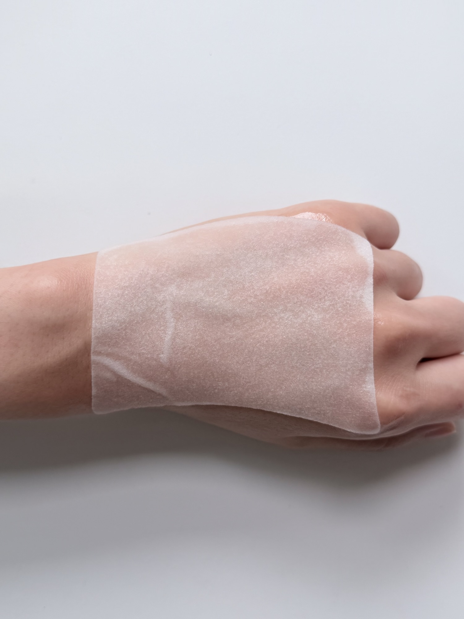 Rejuran toner pad adhesion test on the back of hand — sticks well with cooling sensation
