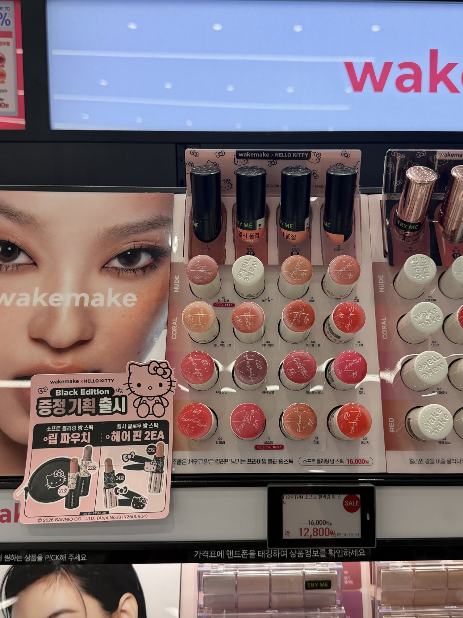 Wakemake Blurring Balm Stick full shade range on display at Olive Young — NUDE, CORAL, RED rows, sale price 12,800 KRW