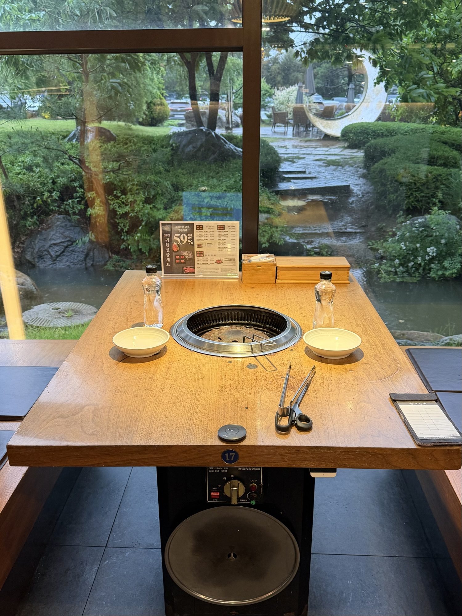 Dining table with charcoal grill at Songdo Galbi — the garden-view window tables are worth asking for