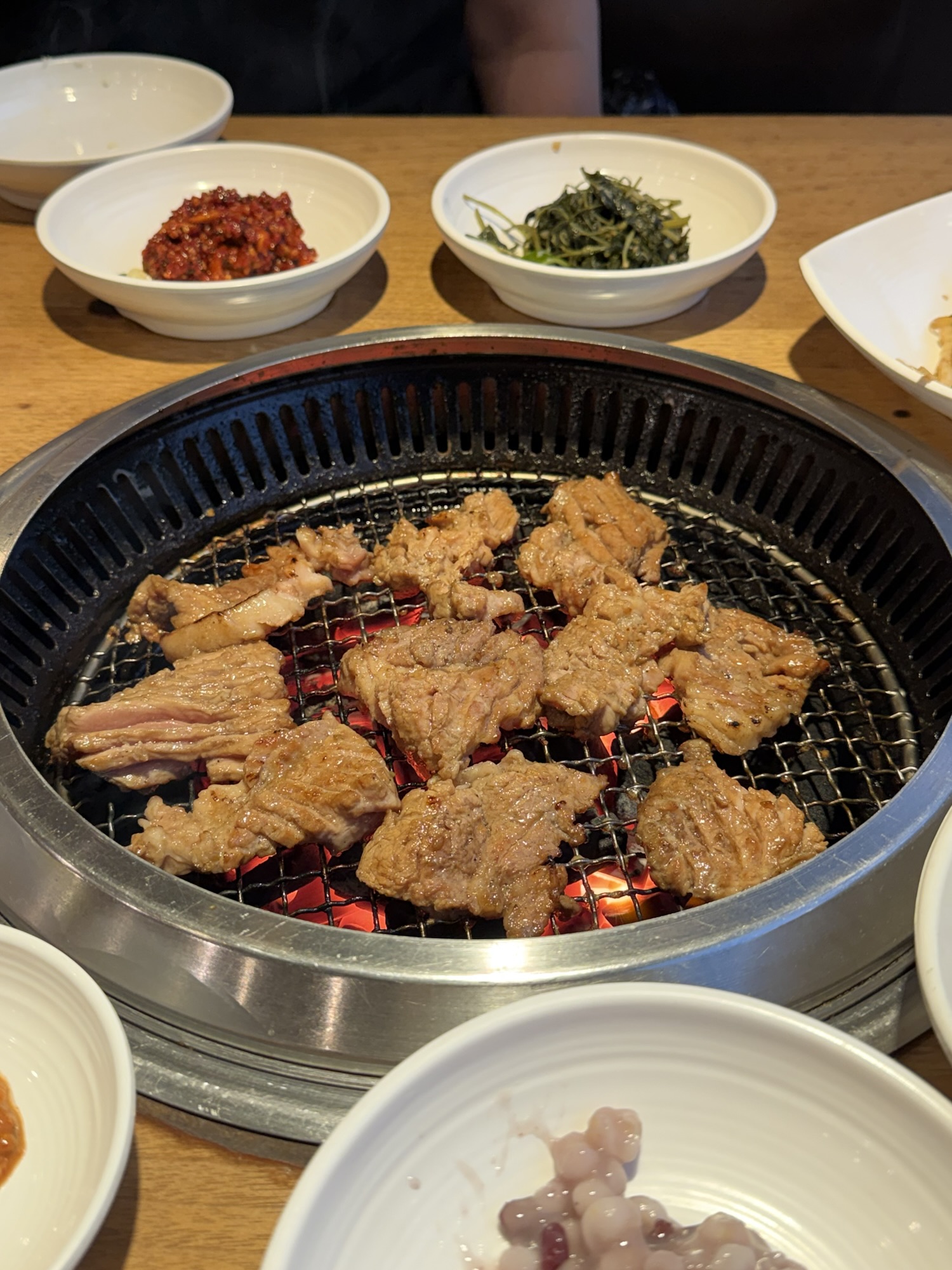 Pork galbi grilling over charcoal at Songdo Galbi — the staff does all the grilling and cuts everything to bite size for you