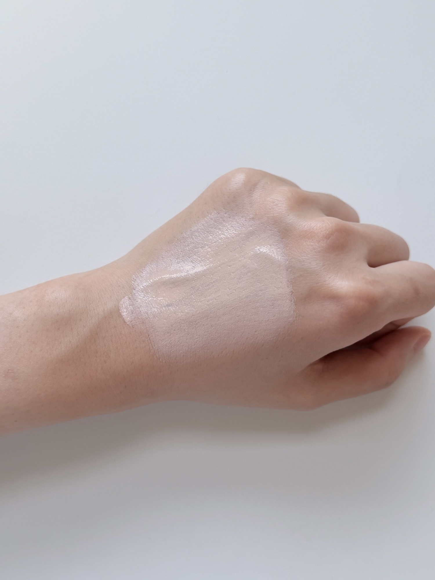 Chasing Rabbit Glow Cover Cream spread across the back of a hand showing tone-up finish mid-application