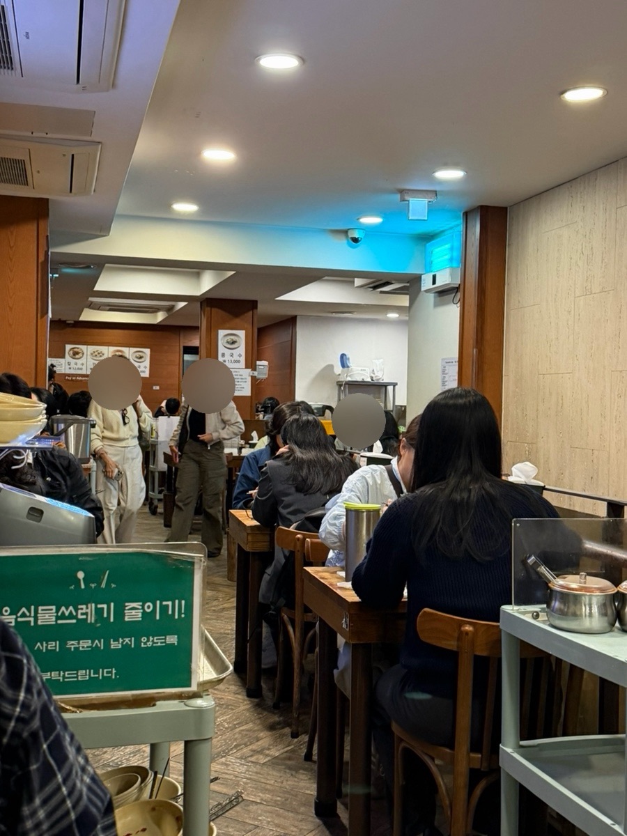 Second floor dining room at Myeongdong Kyoja main branch with diners seated at wooden tables