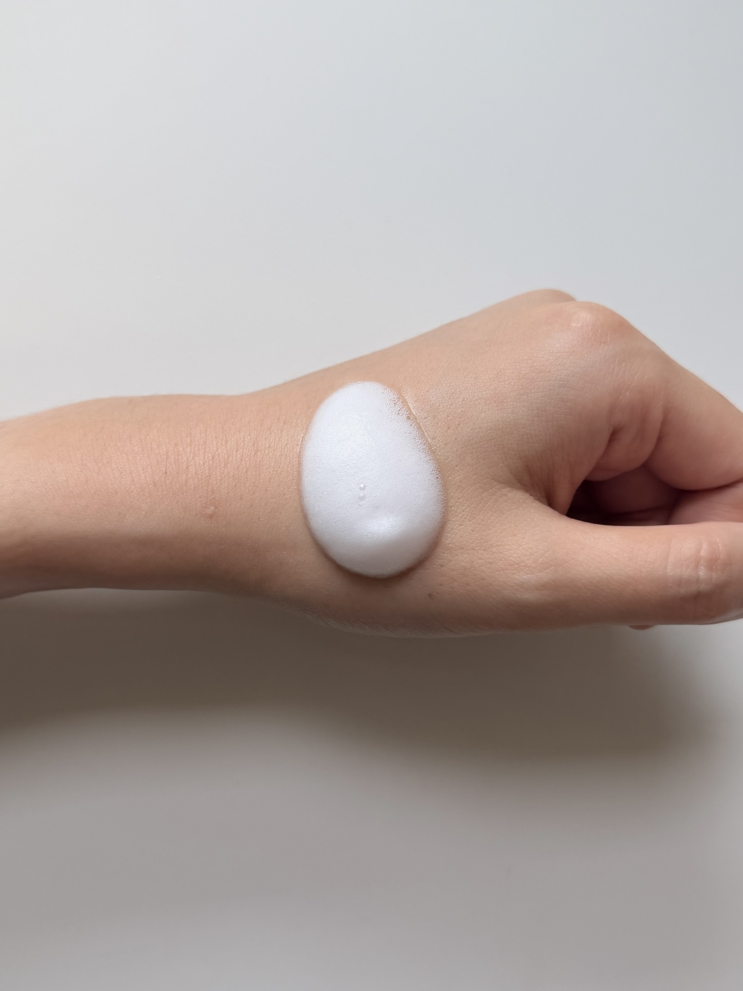 One pump of MENOKIN Lift Bubble Mask foam on the back of a hand