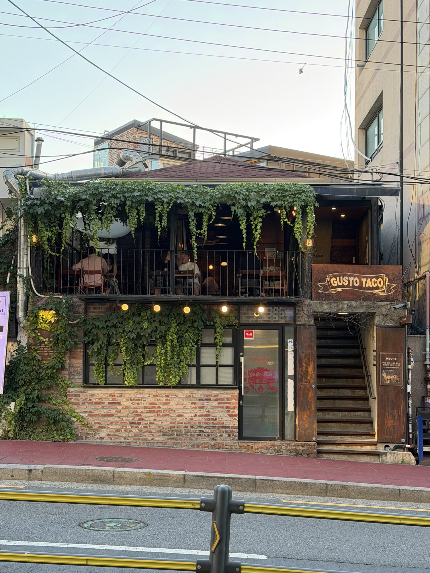 Exterior of Gusto Taco near Sangsu Station with greenery on the brick building