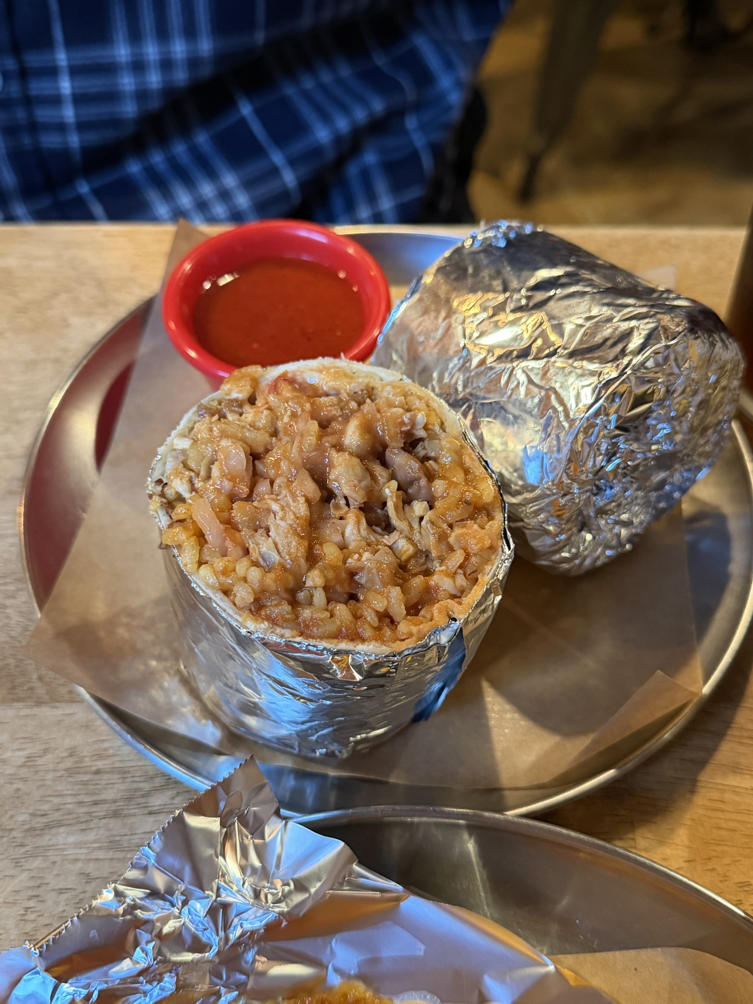 Chicken burrito at Gusto Taco cut open to show the moist filling