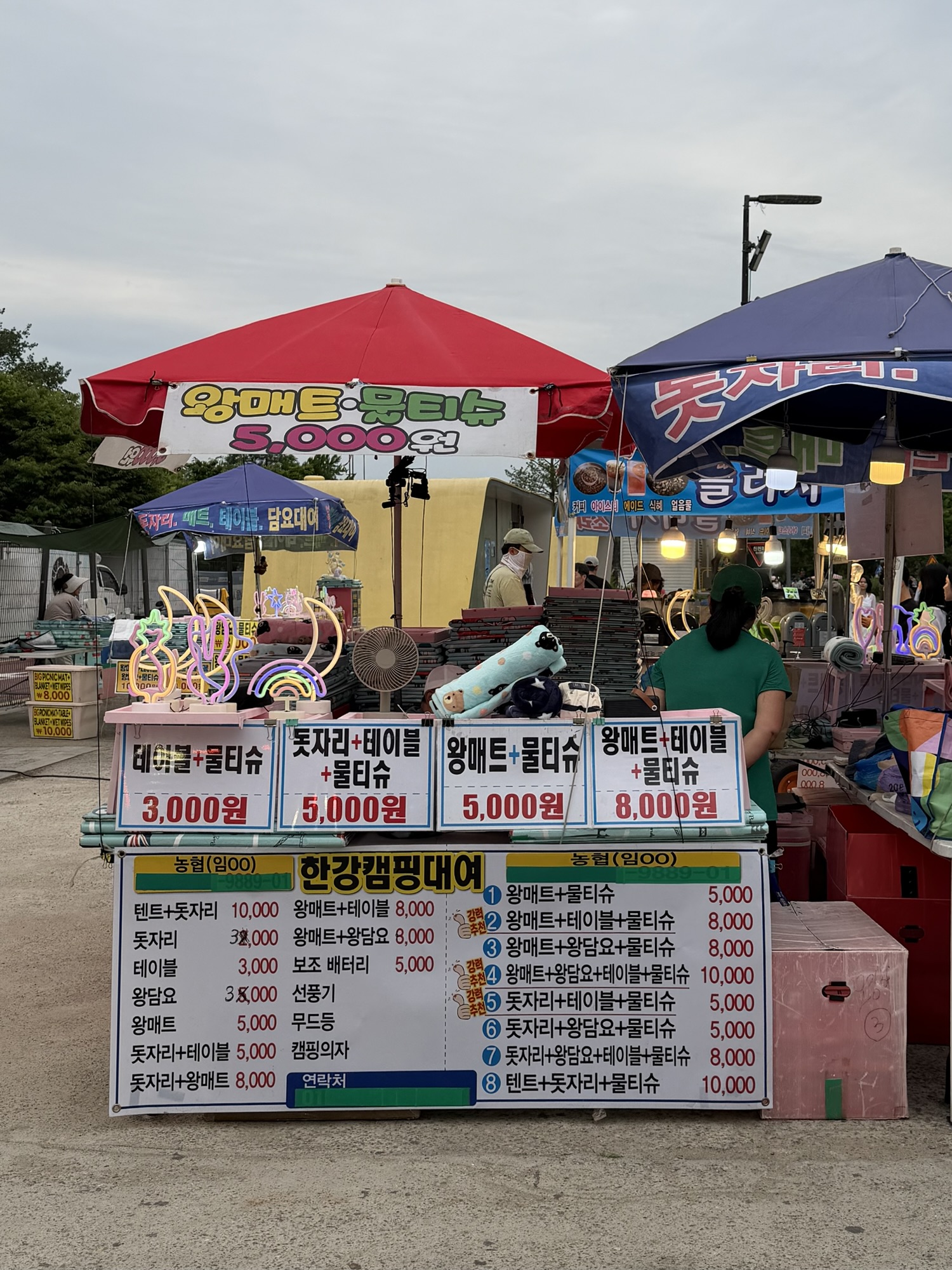 Picnic mat and table rental stall at Yeouido Hangang Park with prices displayed in Korean