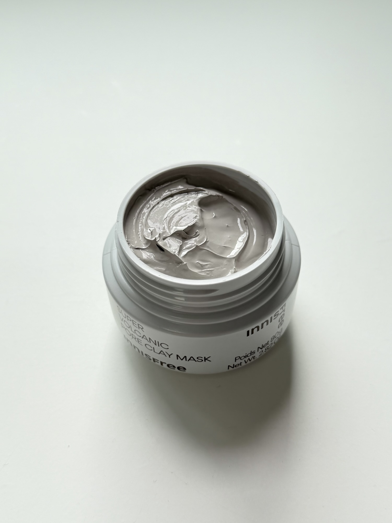 Opened jar of Innisfree Super Volcanic Pore Clay Mask showing gray clay texture