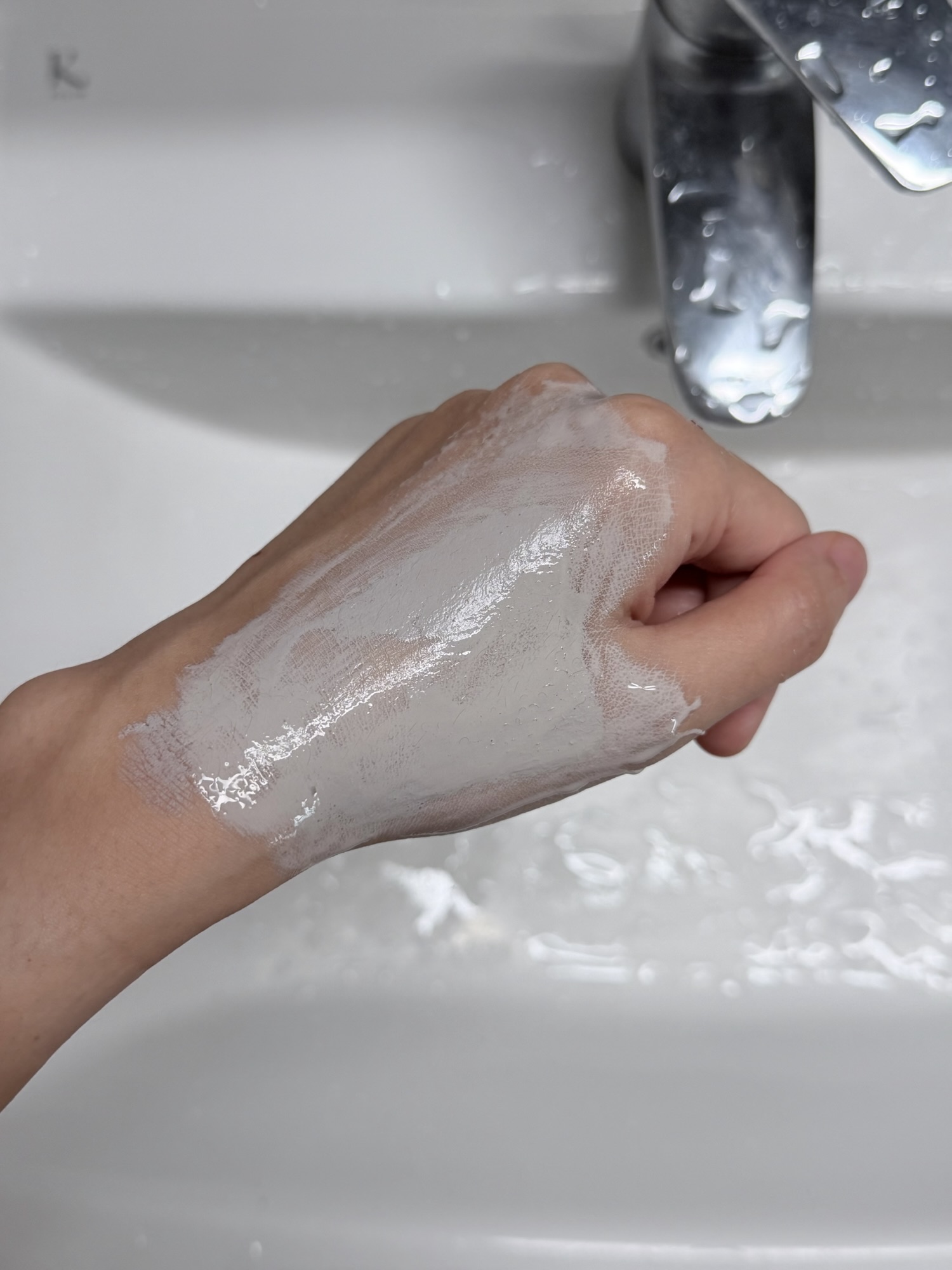 Innisfree Super Volcanic Pore Clay Mask being rinsed off under lukewarm water