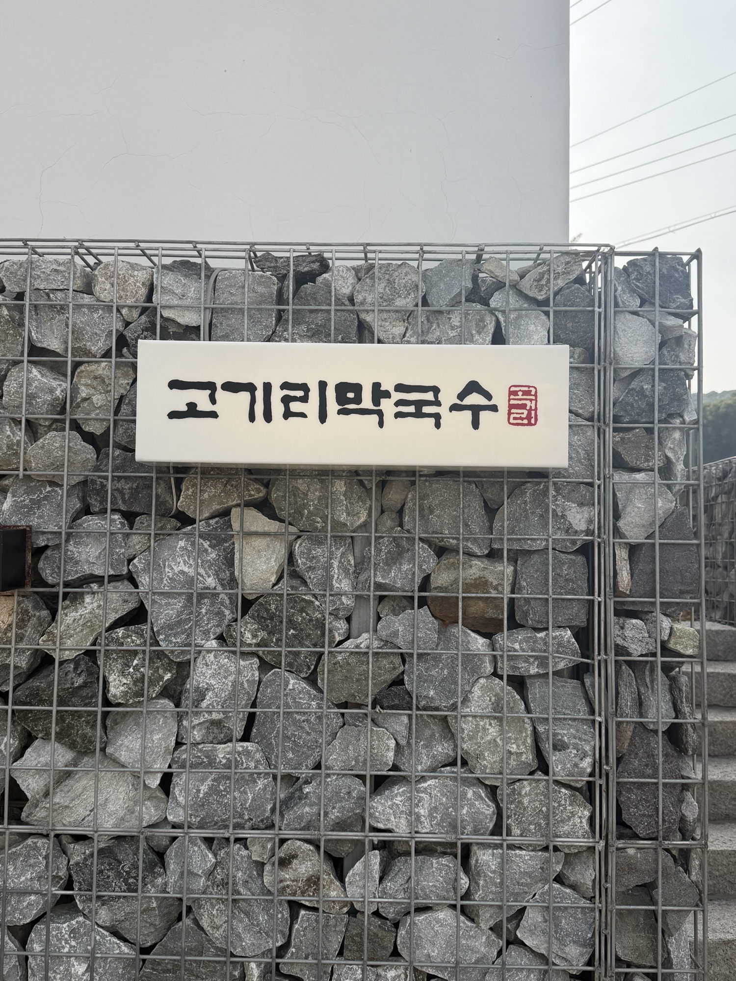 Stone wall sign outside Gogiri Makguksu in Yongin