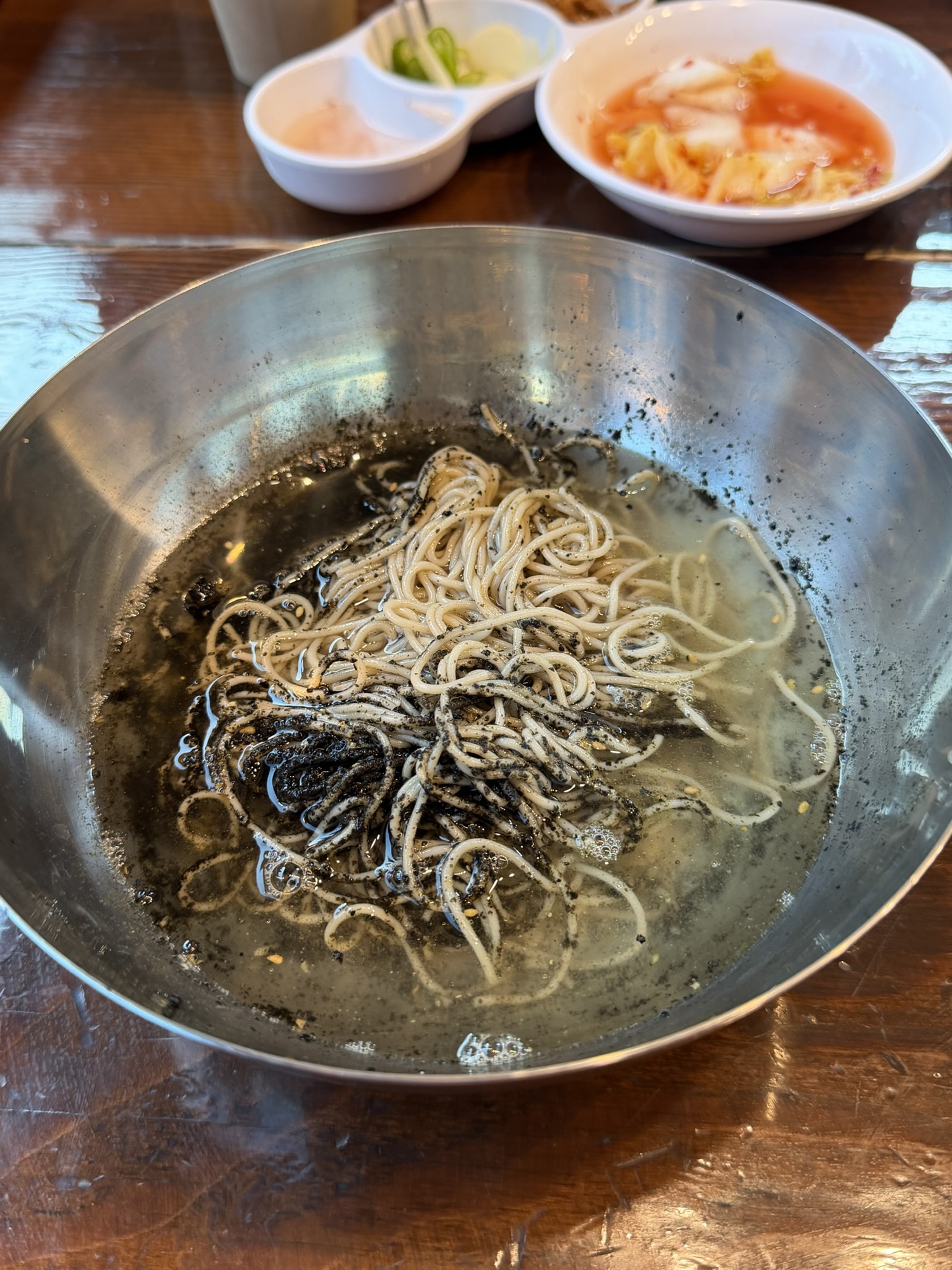 Cold broth poured into leftover perilla oil makguksu at Gogiri Makguksu