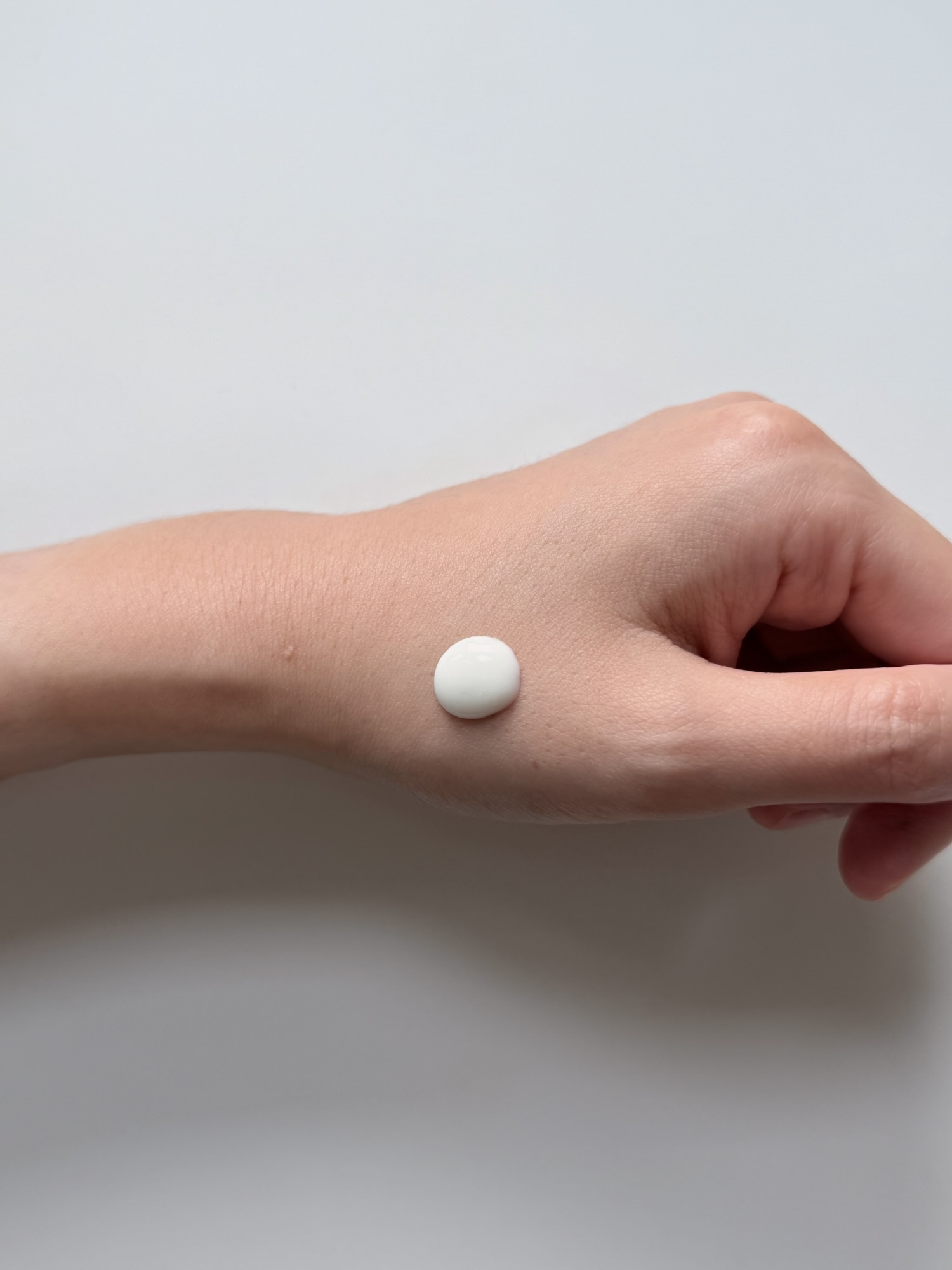 Small amount of ILLIYOON Ceramide Ato Sun Lotion on the back of a hand