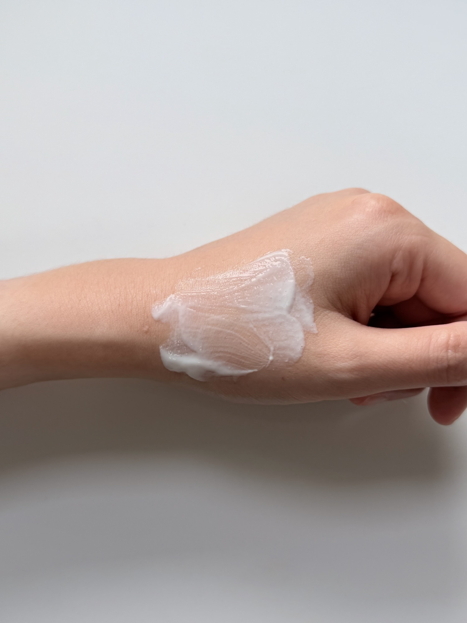ILLIYOON Ceramide Ato Sun Lotion spread across the back of a hand