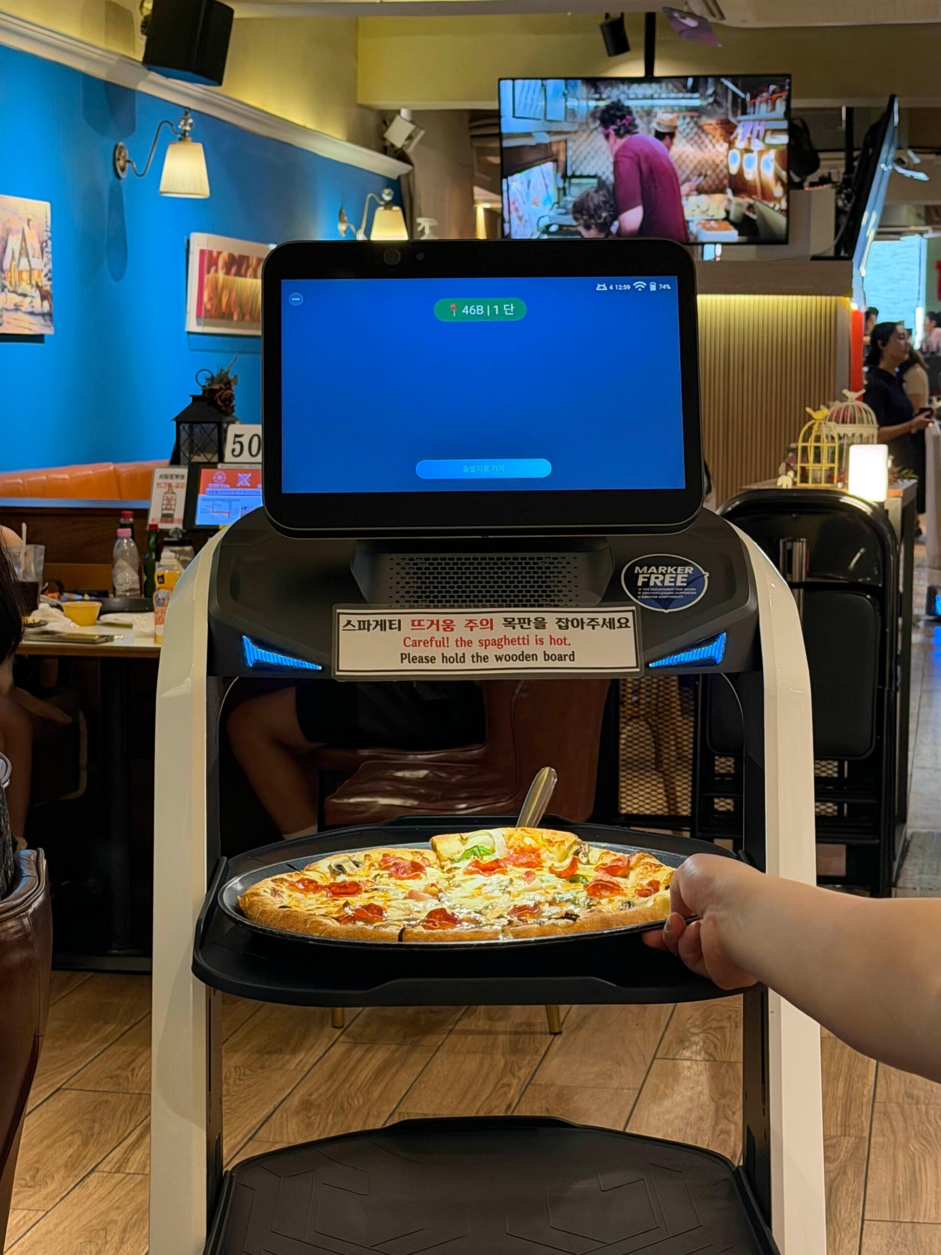 Serving robot bringing pizza at Lee Jaemo Pizza