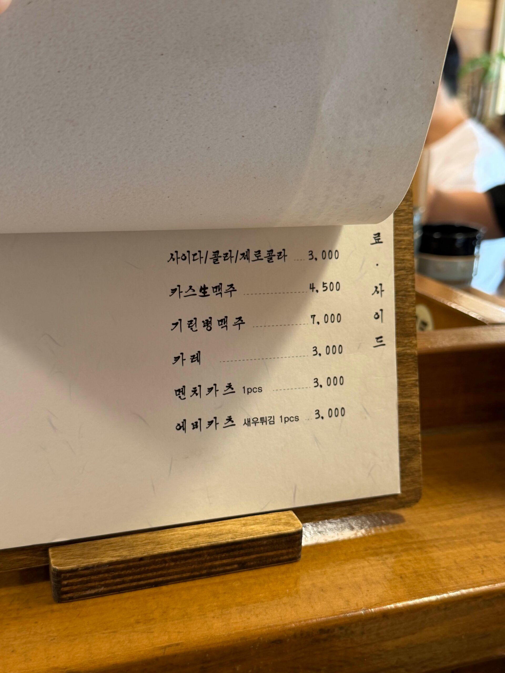 Drink and side menu at Tonshou Busan with beer, curry, and fried side dishes