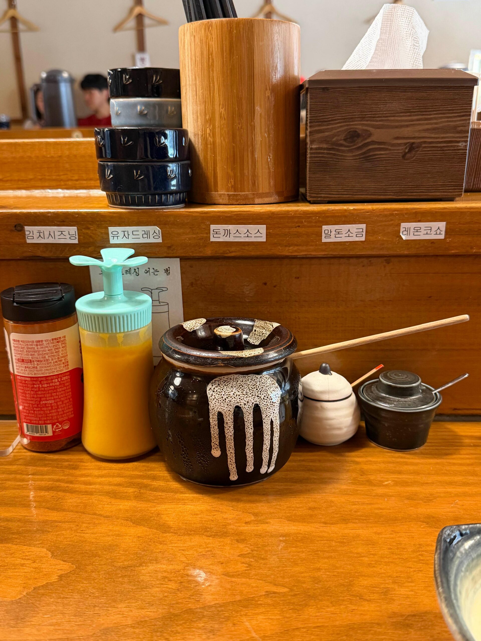 Sauce and seasoning station at a bar seat inside Tonshou Busan
