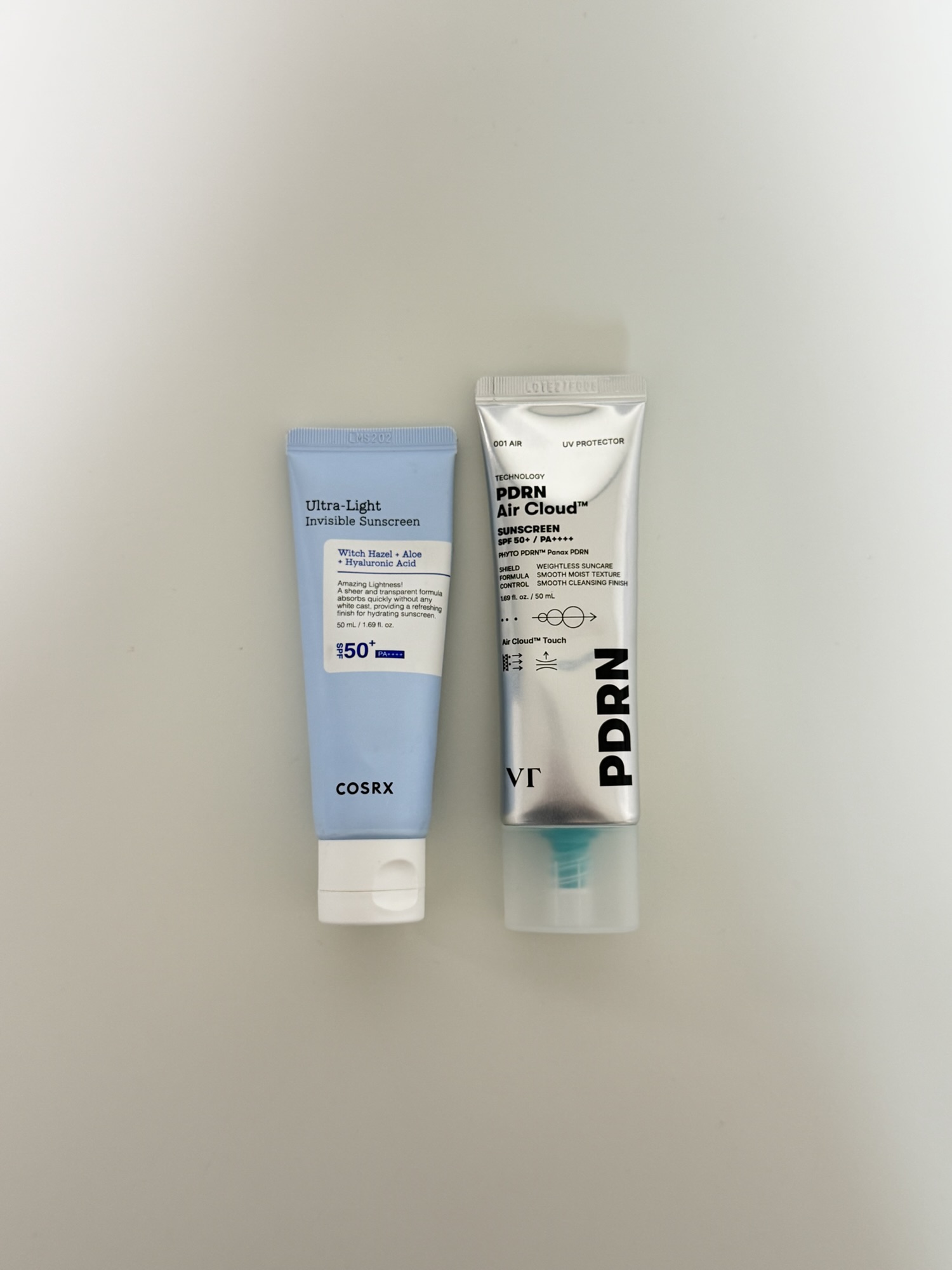 VT PDRN Air Cloud Sunscreen next to COSRX Ultra Light Invisible Sunscreen