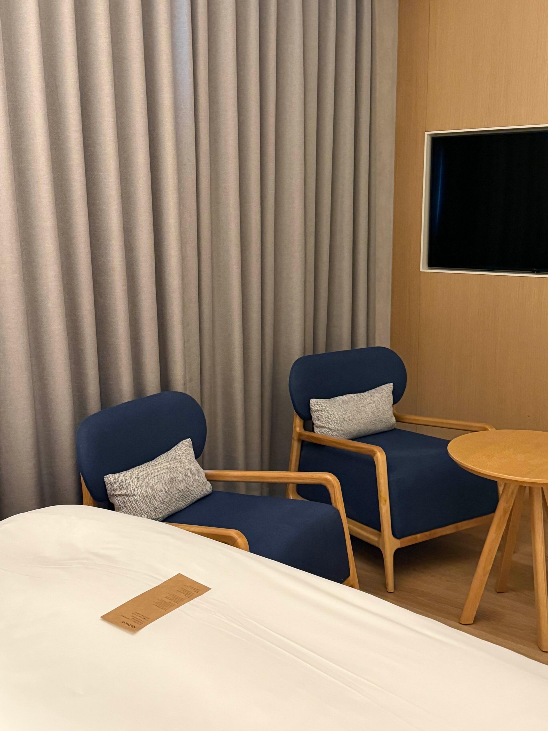 Bed and sofa chairs inside L7 Haeundae Superior Queen room