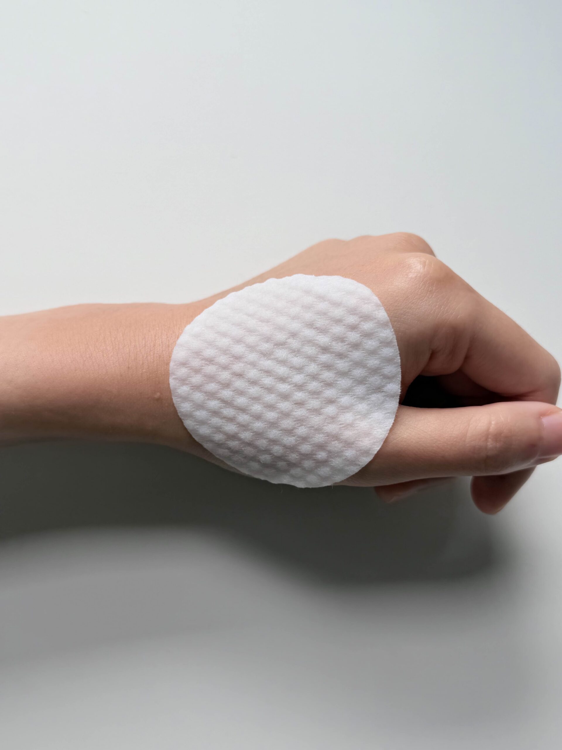 Textured side of Medicube Zero Pore Pad 2.0 toner pad on fingers