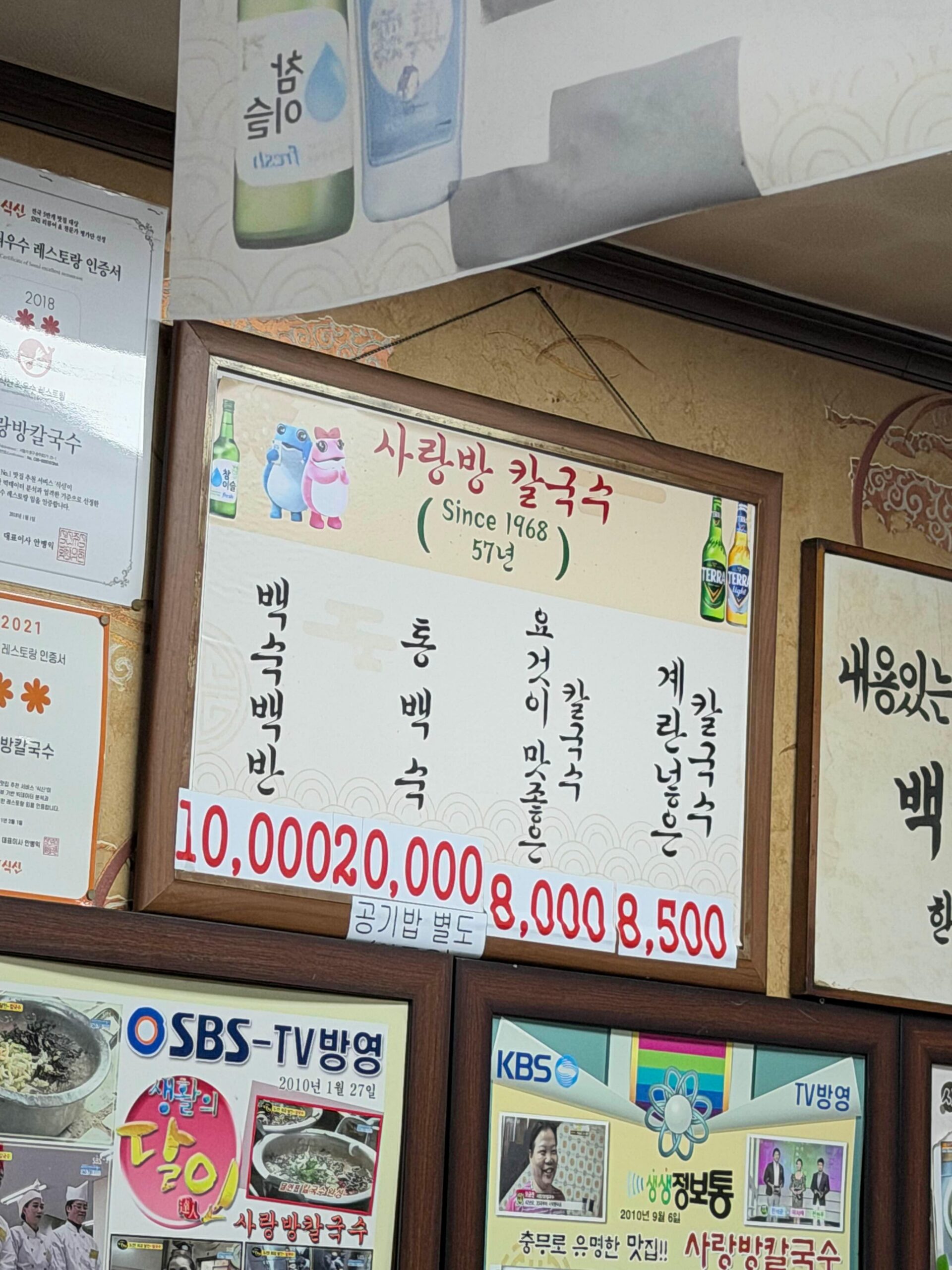 Simple menu board at Sarangbang Kalguksu showing baeksuk baekban and kalguksu