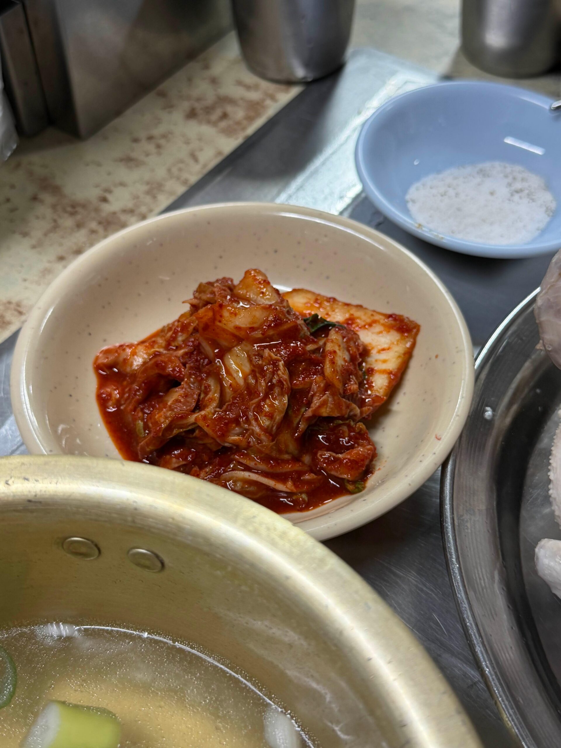 Kimchi side dish served with baeksuk and kalguksu at Sarangbang Kalguksu