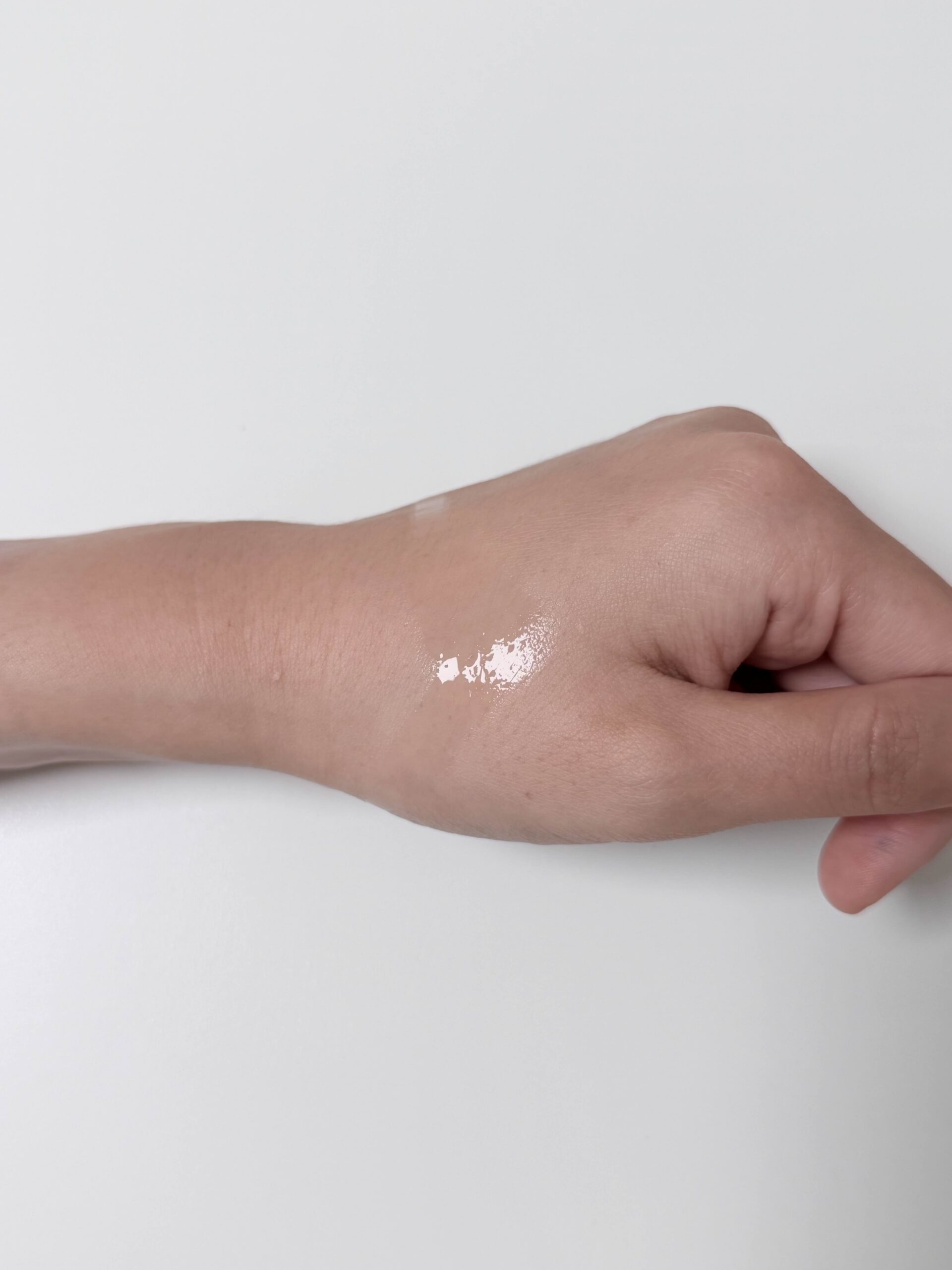Daiso VT PDRN Glow Toner texture drops on the back of a hand