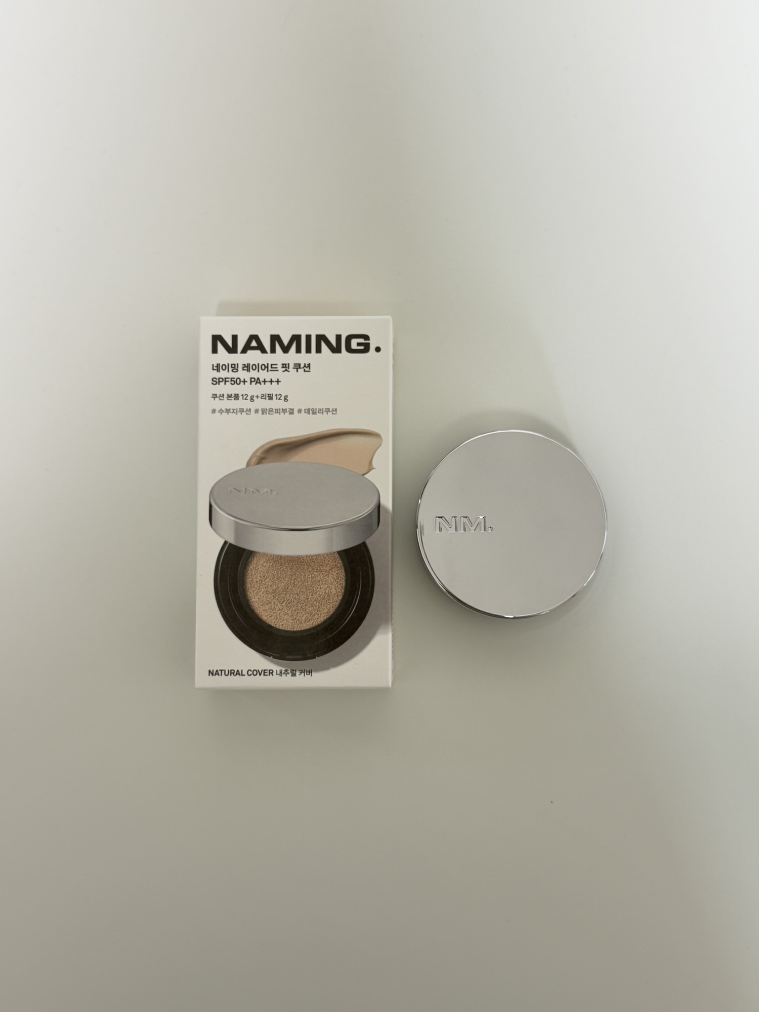 NAMING Layered Fit Cushion silver compact next to the product box
