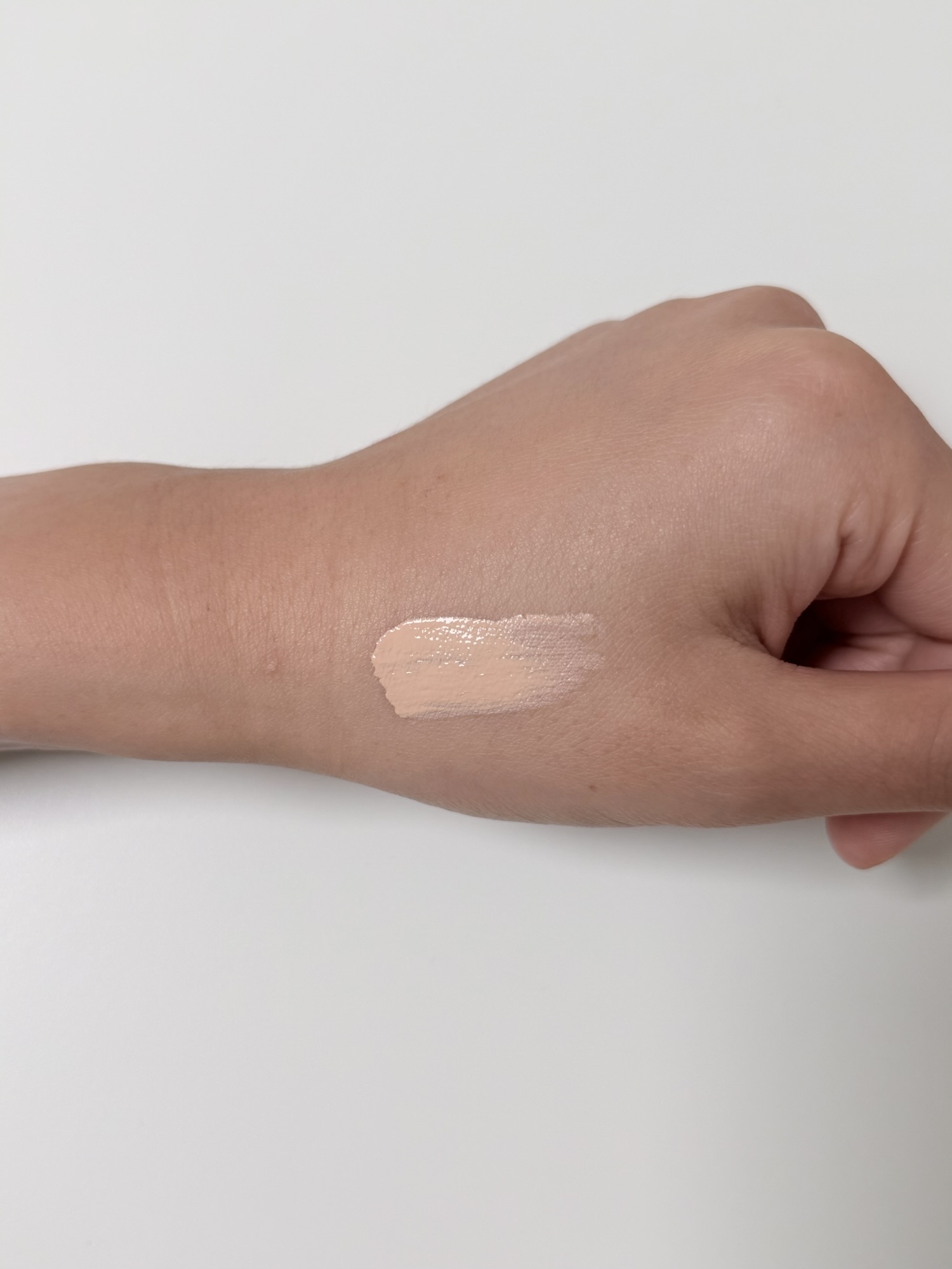 NAMING Layered Fit Cushion 21Y swatched on the back of a hand