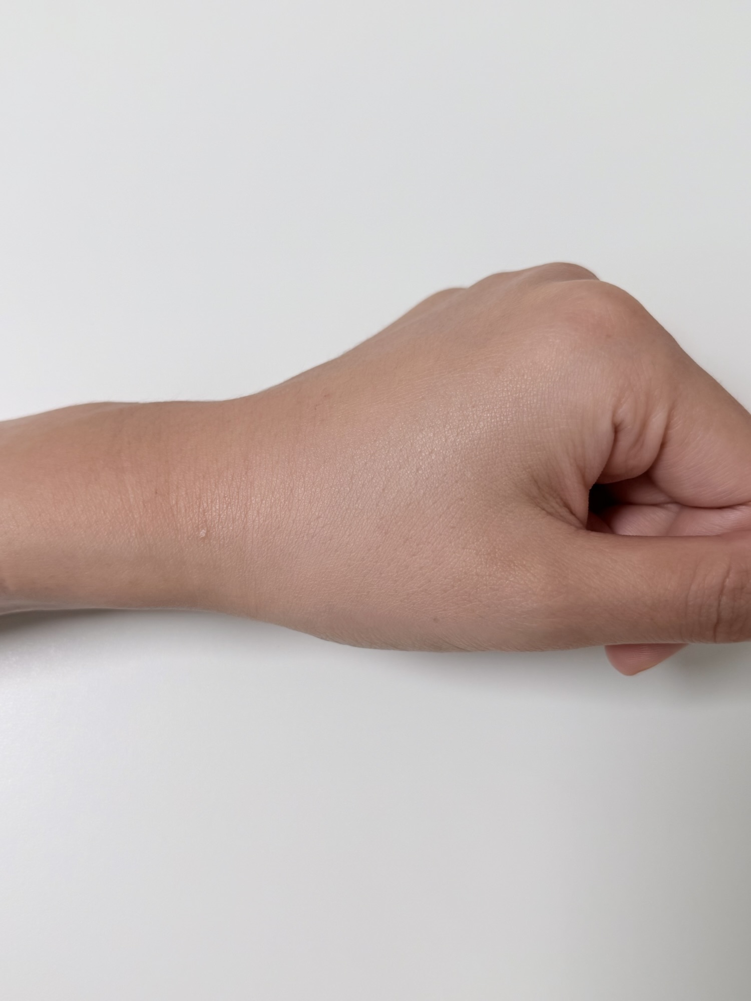 Back of hand after applying NAMING Layered Fit Cushion over lip and eyebrow swatches