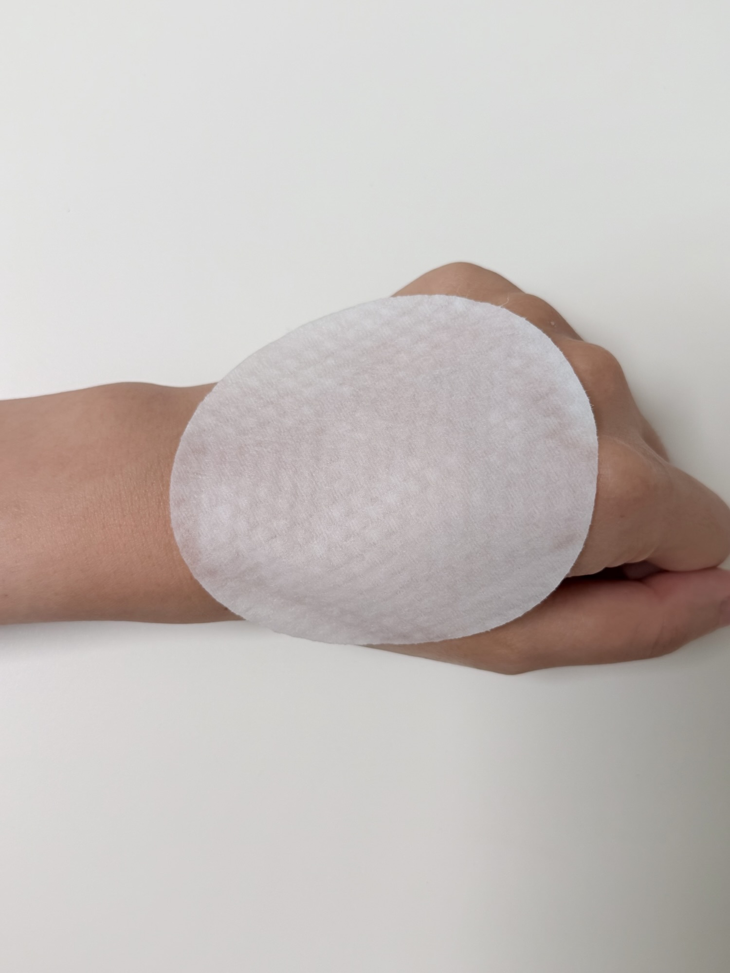 Smooth side of Needly toner pad on the back of a hand